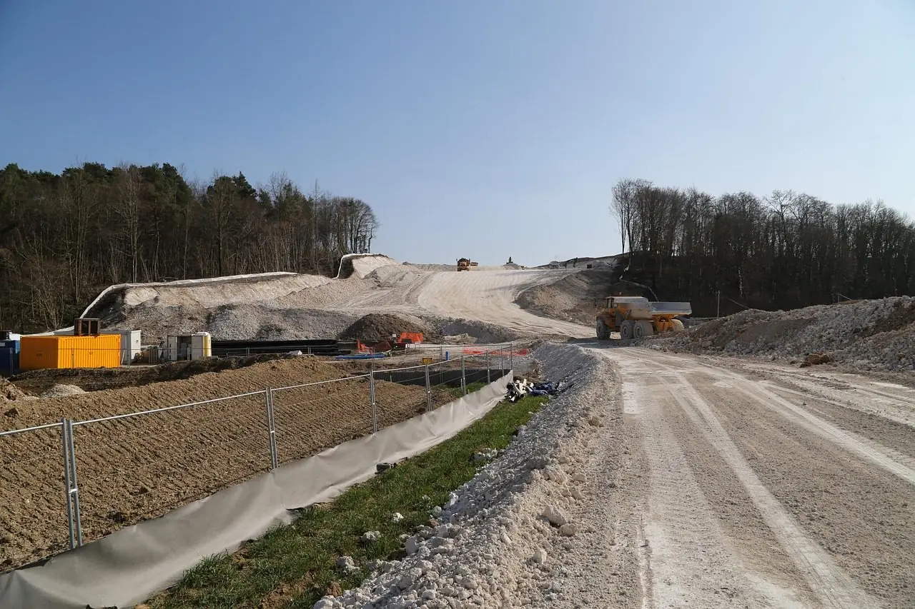Dirt haul road through a construction site with equipment in the distance